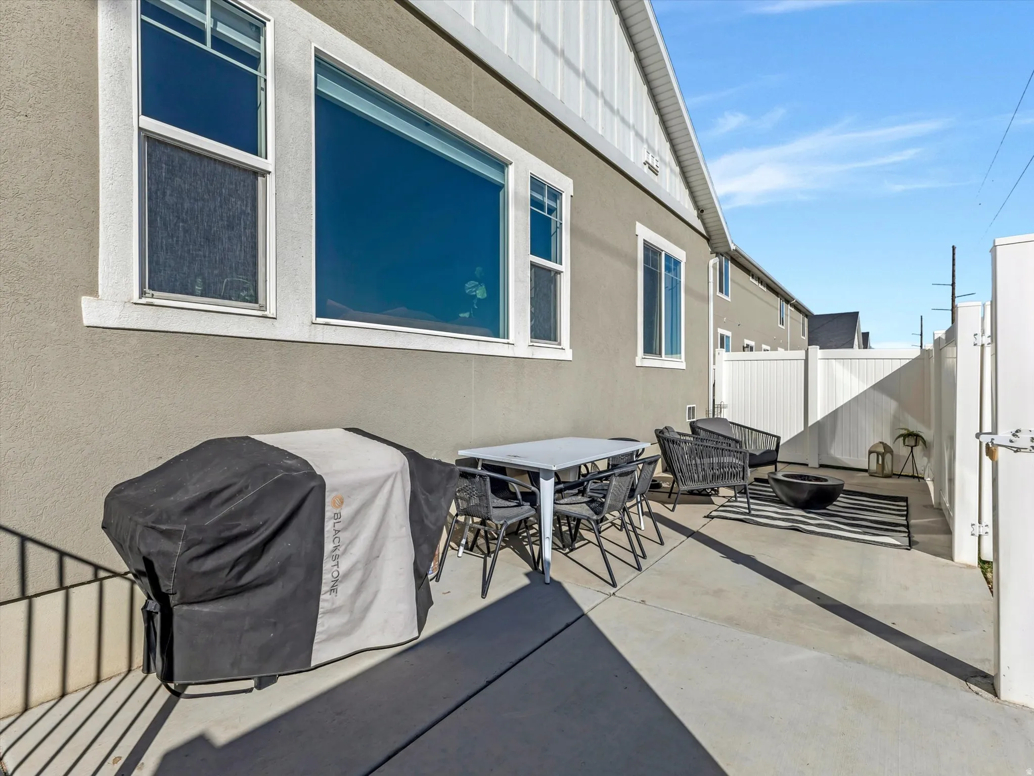 Fenced backyard featuring a grill, a patio area, outdoor dining area, and an outdoor fire pit