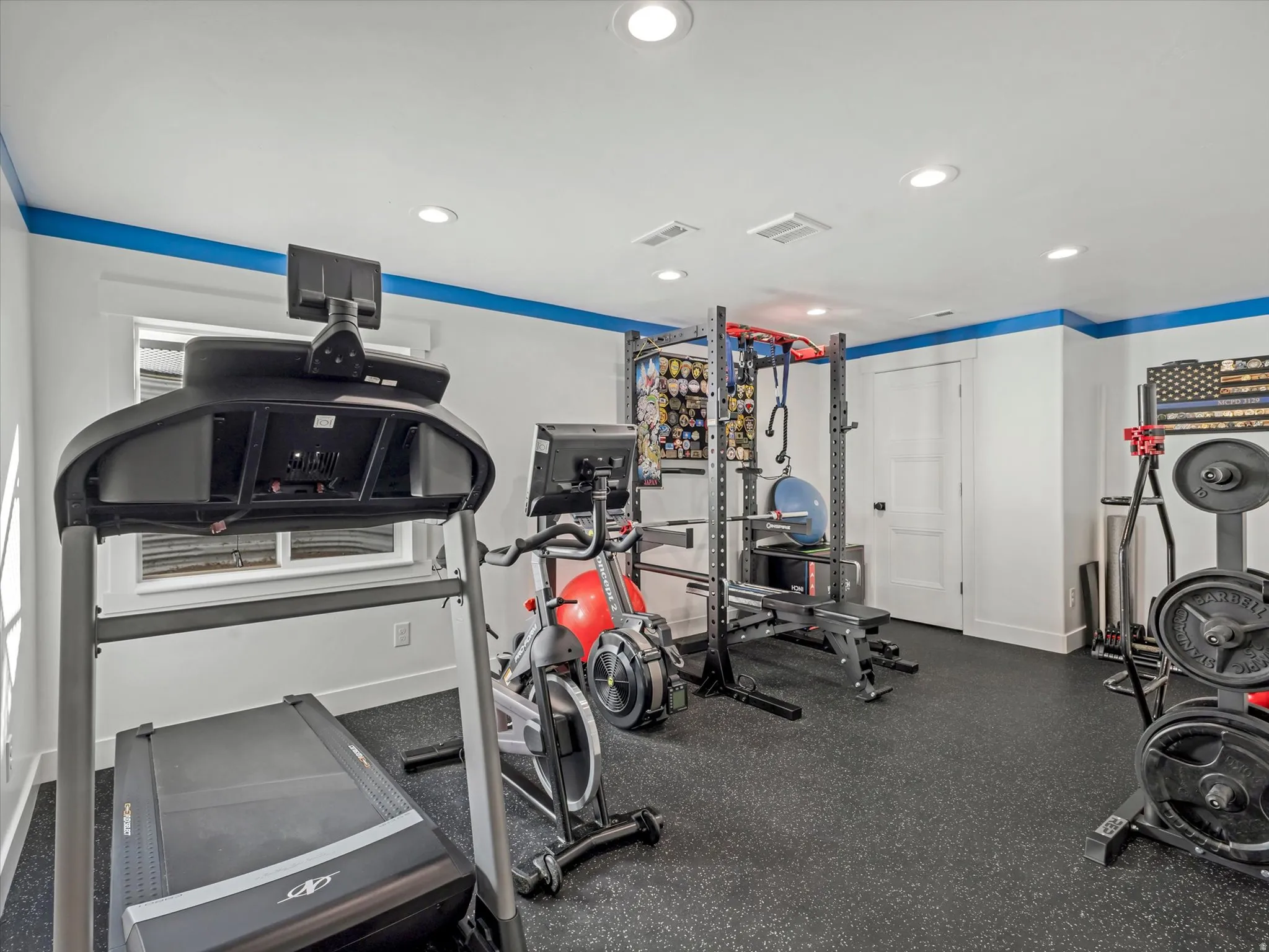 Gym featuring recessed lighting and dark rubber floors