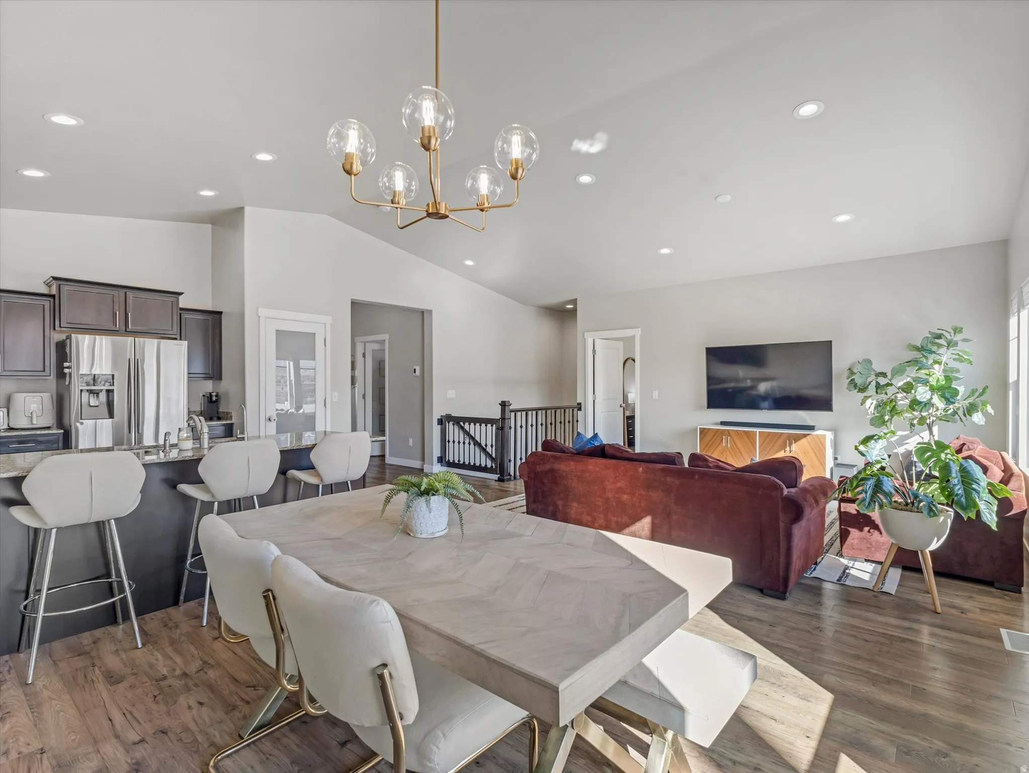 Dining space with dark wood-style flooring, a chandelier, and lofted ceiling