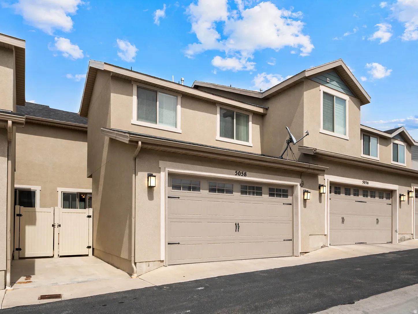 Traditional-style home featuring stucco siding, a gate, and an attached garage