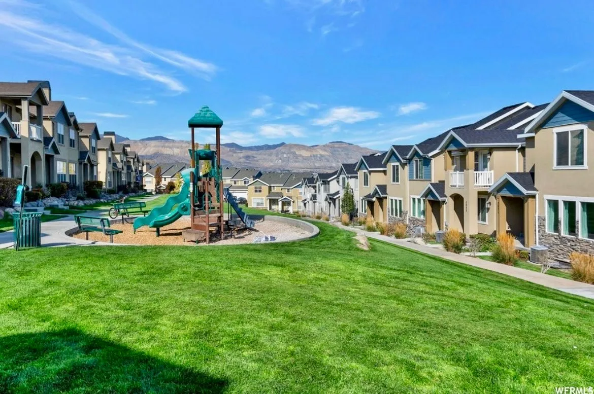 Community jungle gym featuring a residential view, a lawn, and a mountain view