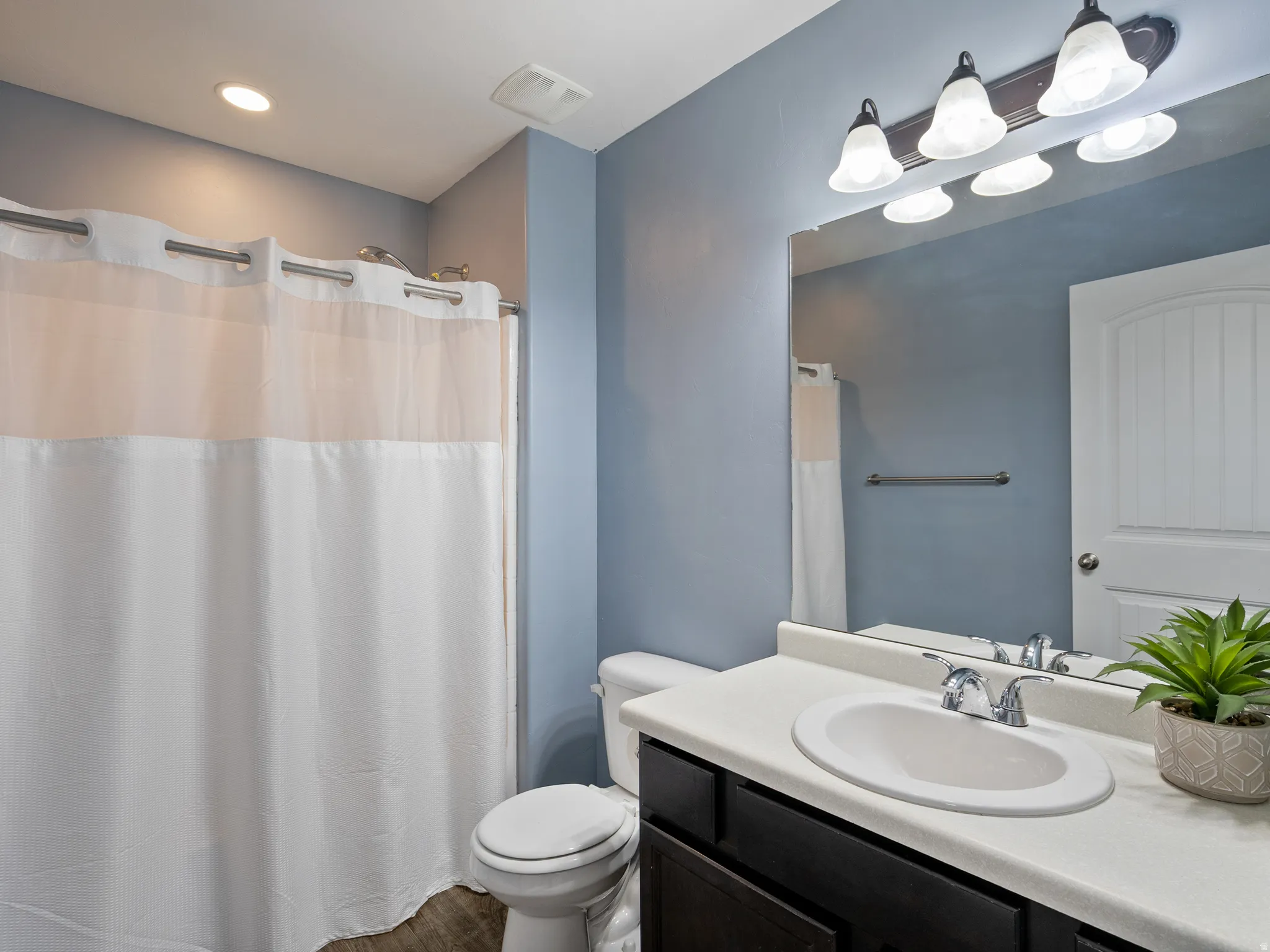 Full bath with vanity, a shower with shower curtain, and recessed lighting