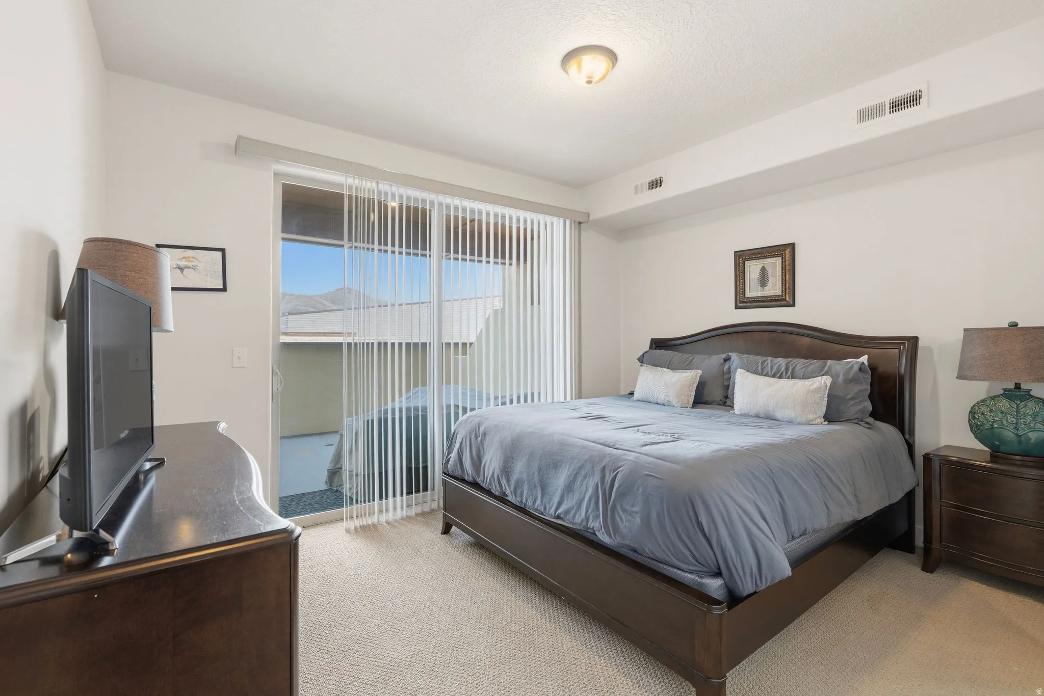 Bedroom with light carpet and access to exterior