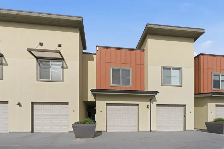 View of front of home featuring board and batten siding, a garage, stucco siding, and driveway