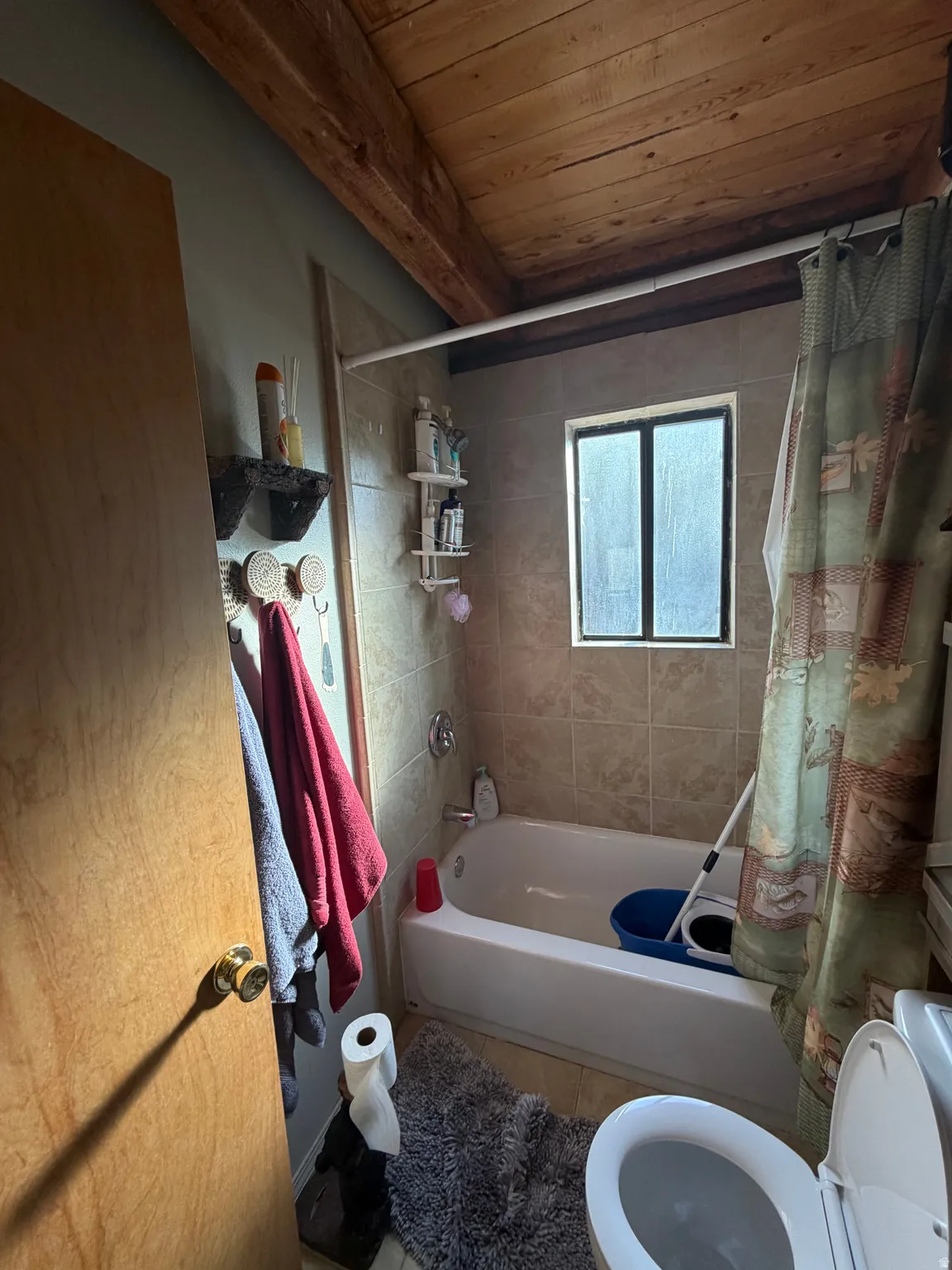 Bathroom featuring shower / tub combo with curtain, wood ceiling, and tile patterned floors