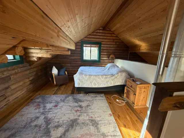 Bedroom with rustic walls, a vaulted wood ceiling, and wood-type flooring