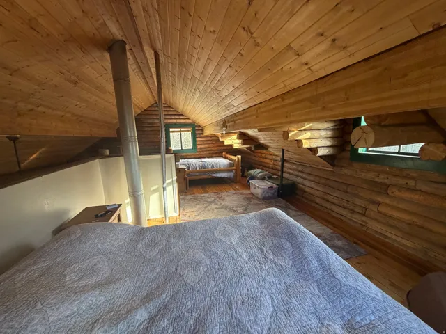 Bedroom featuring rustic walls, a vaulted wood ceiling, and hardwood / wood-style flooring