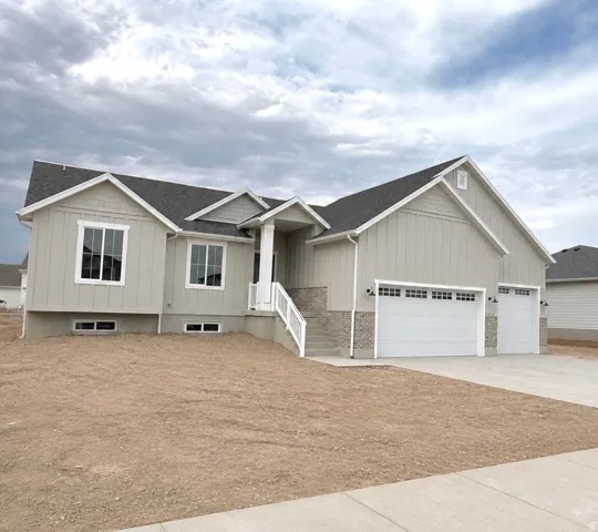 Contemporary exterior featuring vertical siding, stone accents, multiple gables, a covered entry, and dual garage doors