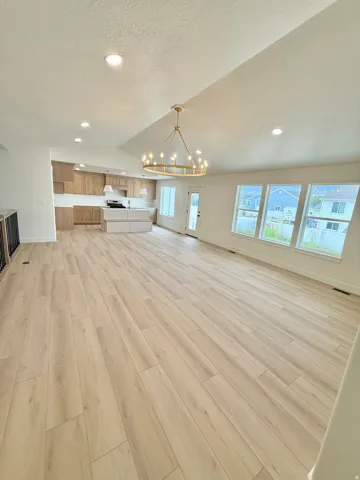 Open-concept great room with vaulted ceilings and wood-finish flooring