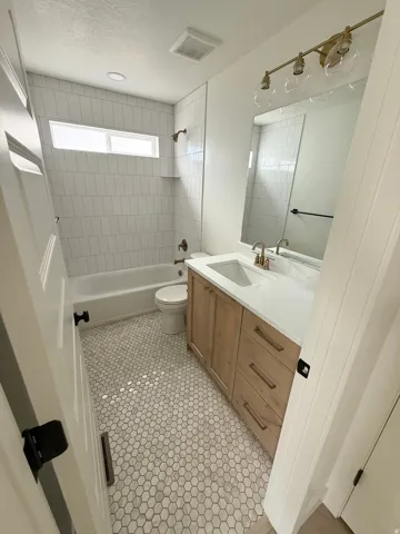 Bathroom featuring a light wood-finish vanity with a white countertop and rectangular undermount sink