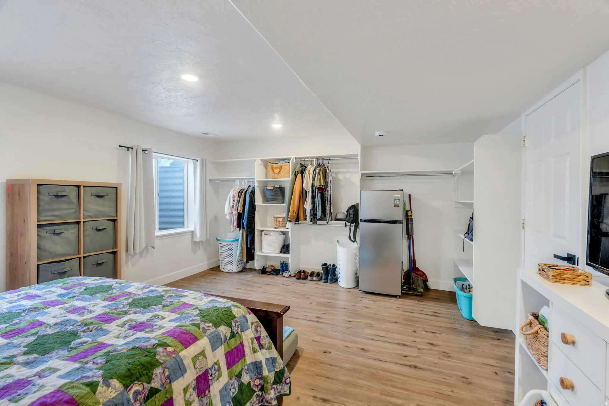 Large basement bedroom with open closets and plenty of storage