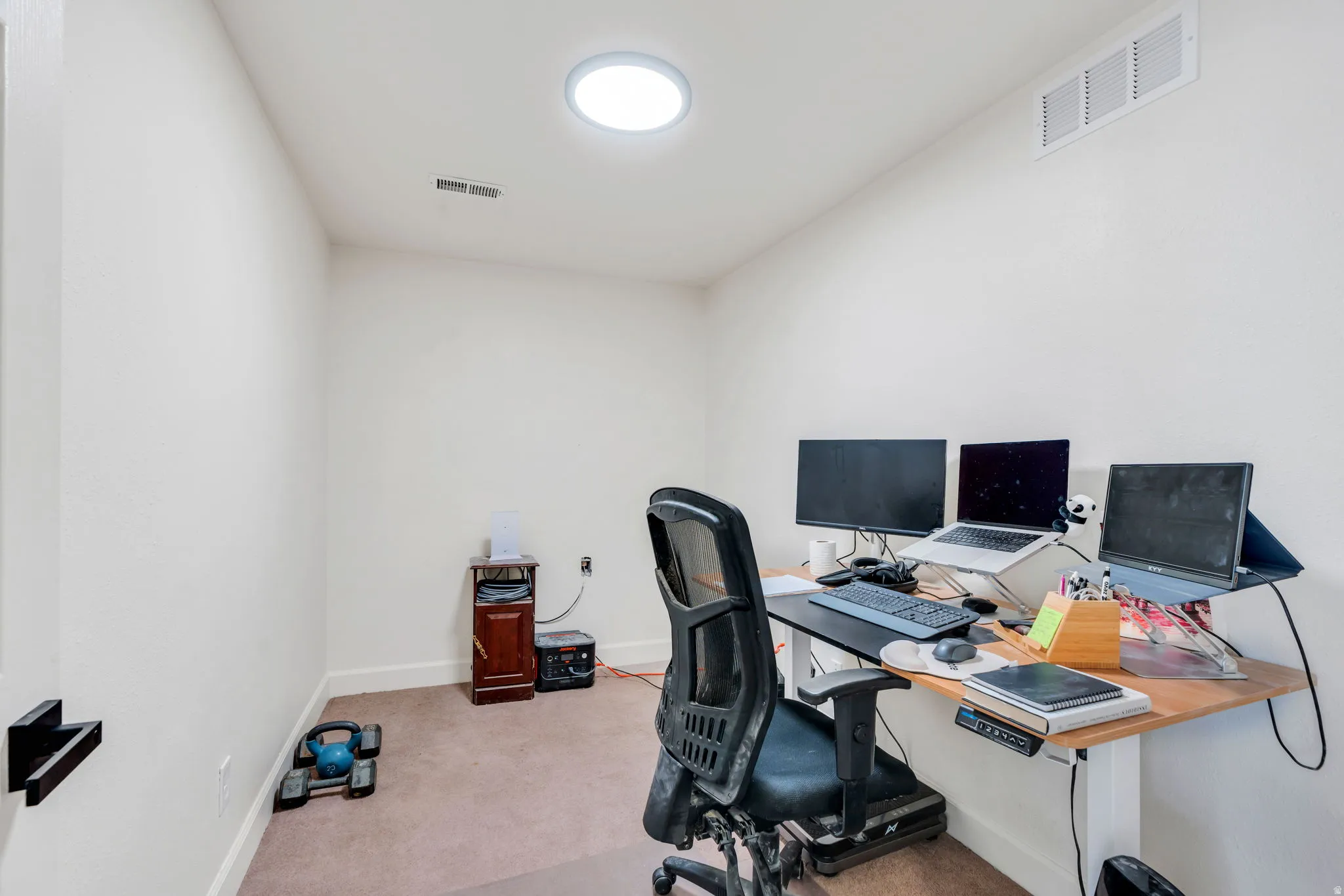 Home office featuring light colored carpet and baseboards