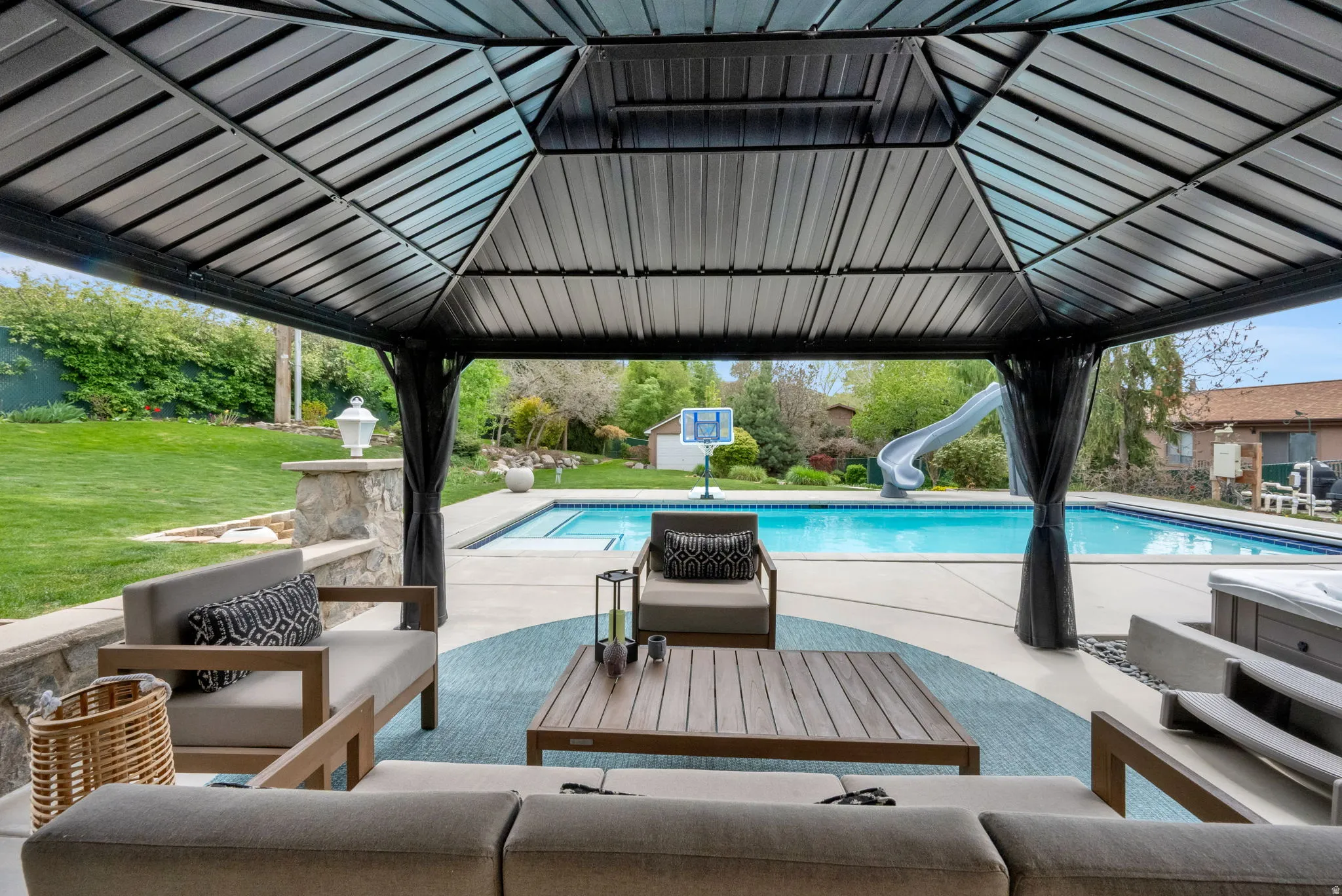 Swimming pool featuring a water slide, outdoor furniture, a patio area, and a lawn
