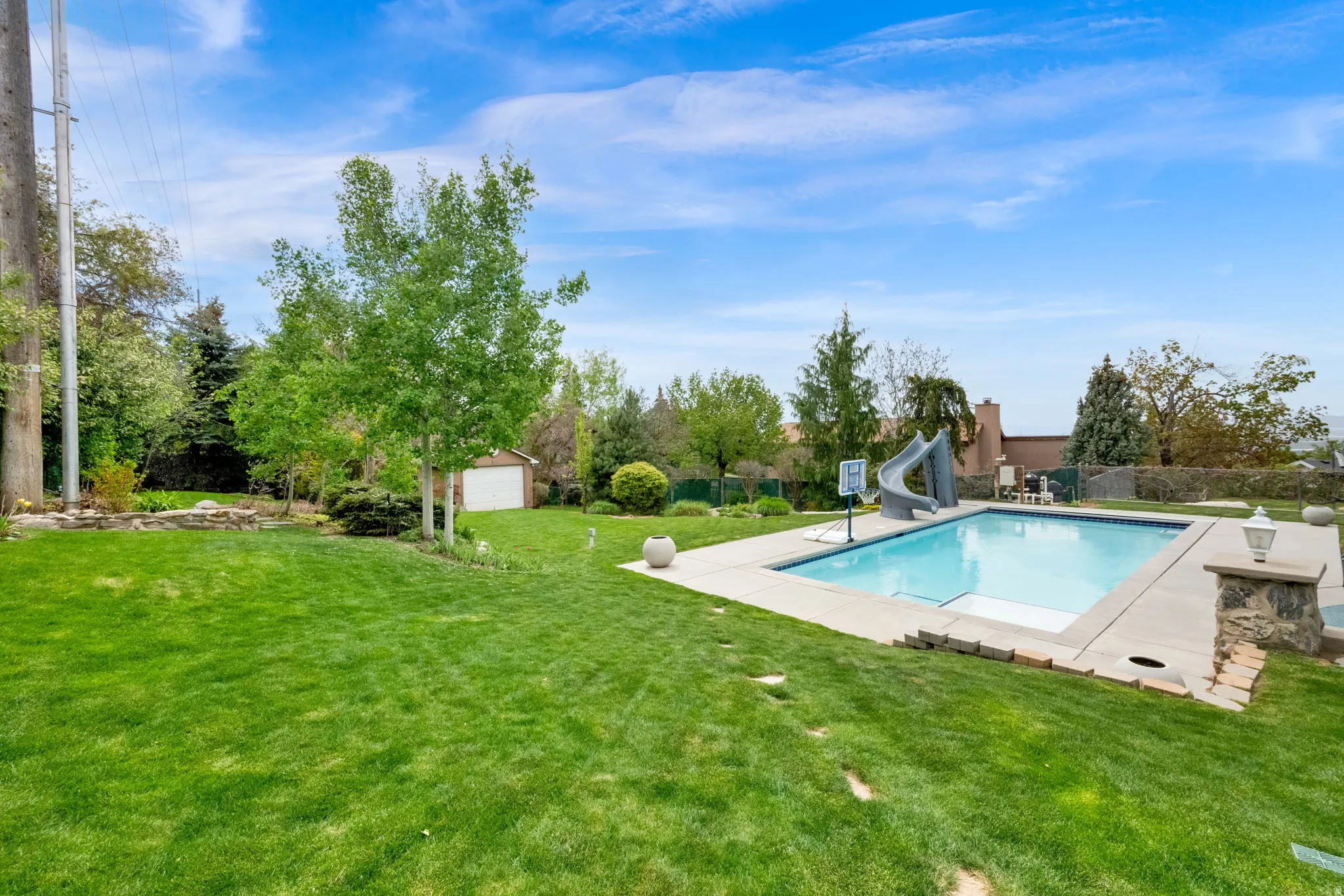 View of pool featuring a water slide, patio surround, and an outdoor structure