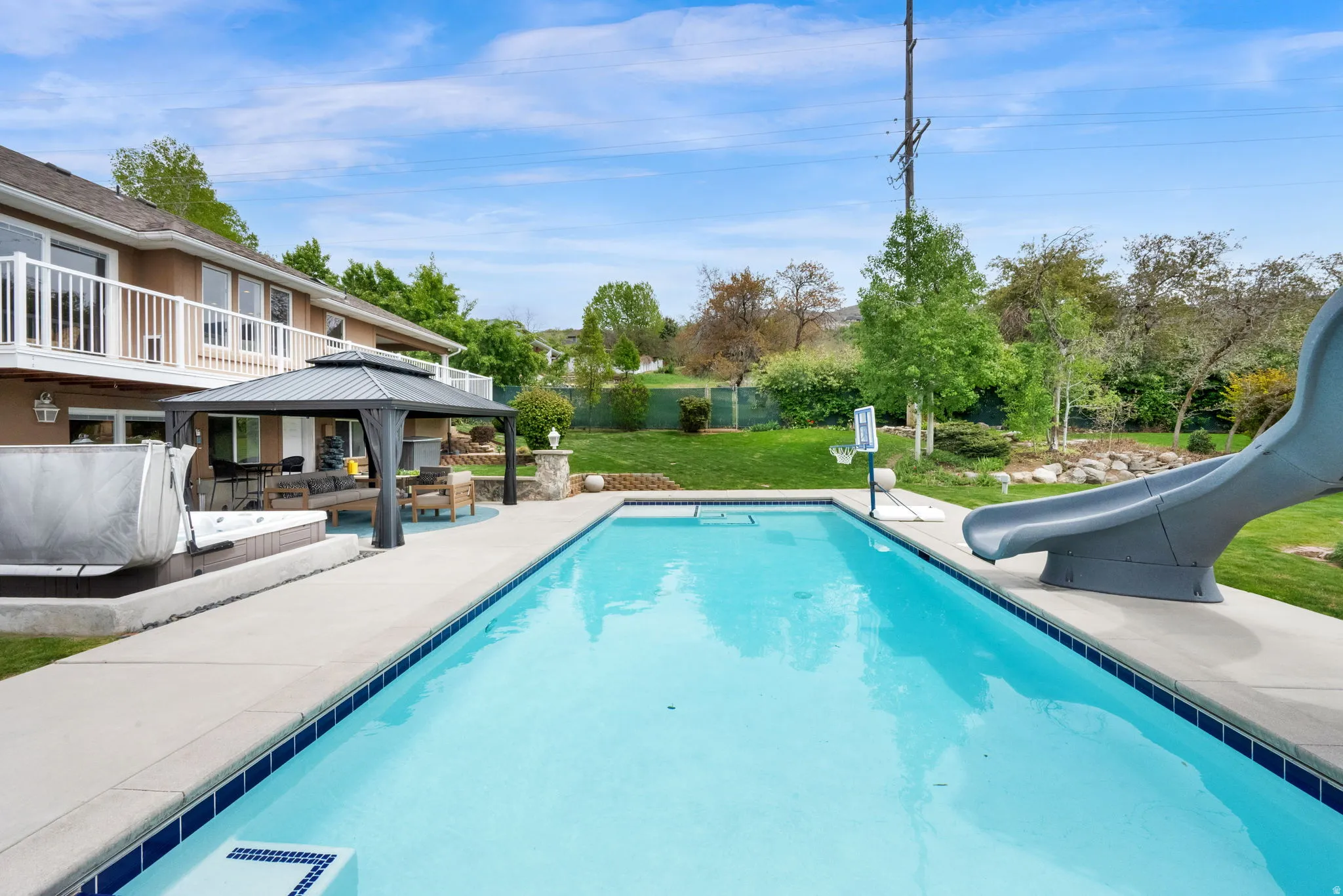 Swimming pool featuring a water slide, a patio, a gazebo, and an outdoor living space
