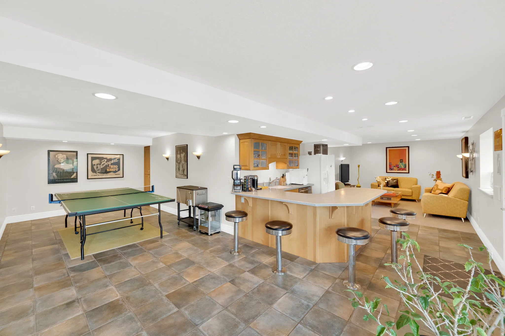 Kitchen featuring a kitchen bar, open floor plan, glass fronted cabinets, a peninsula, and recessed lighting