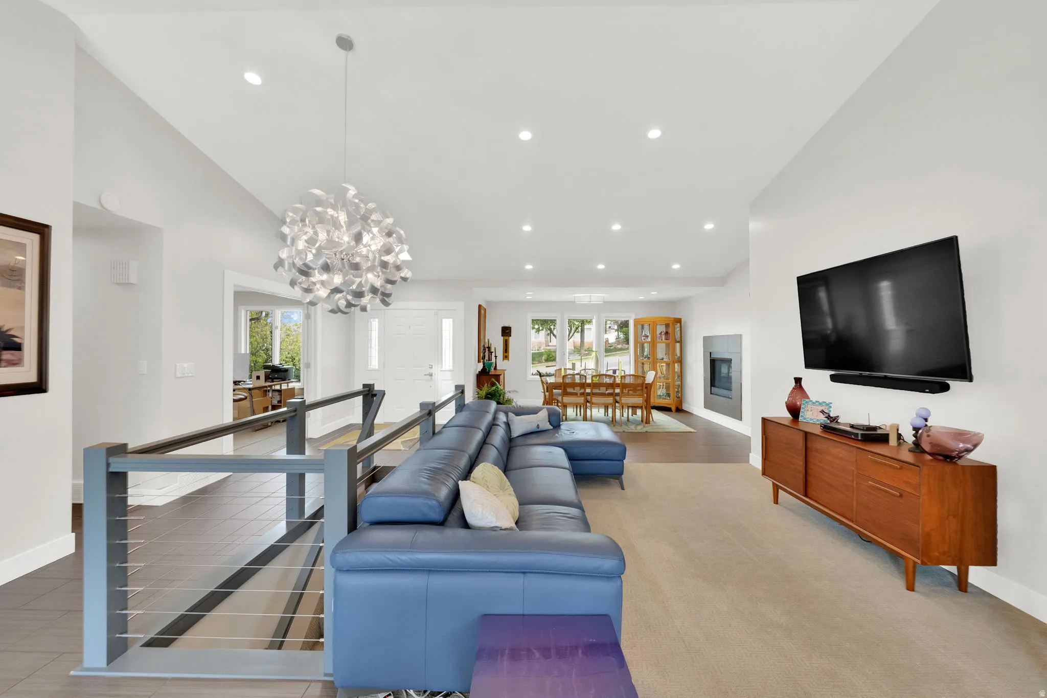 Living area featuring vaulted ceiling, healthy amount of natural light, and hanging lights