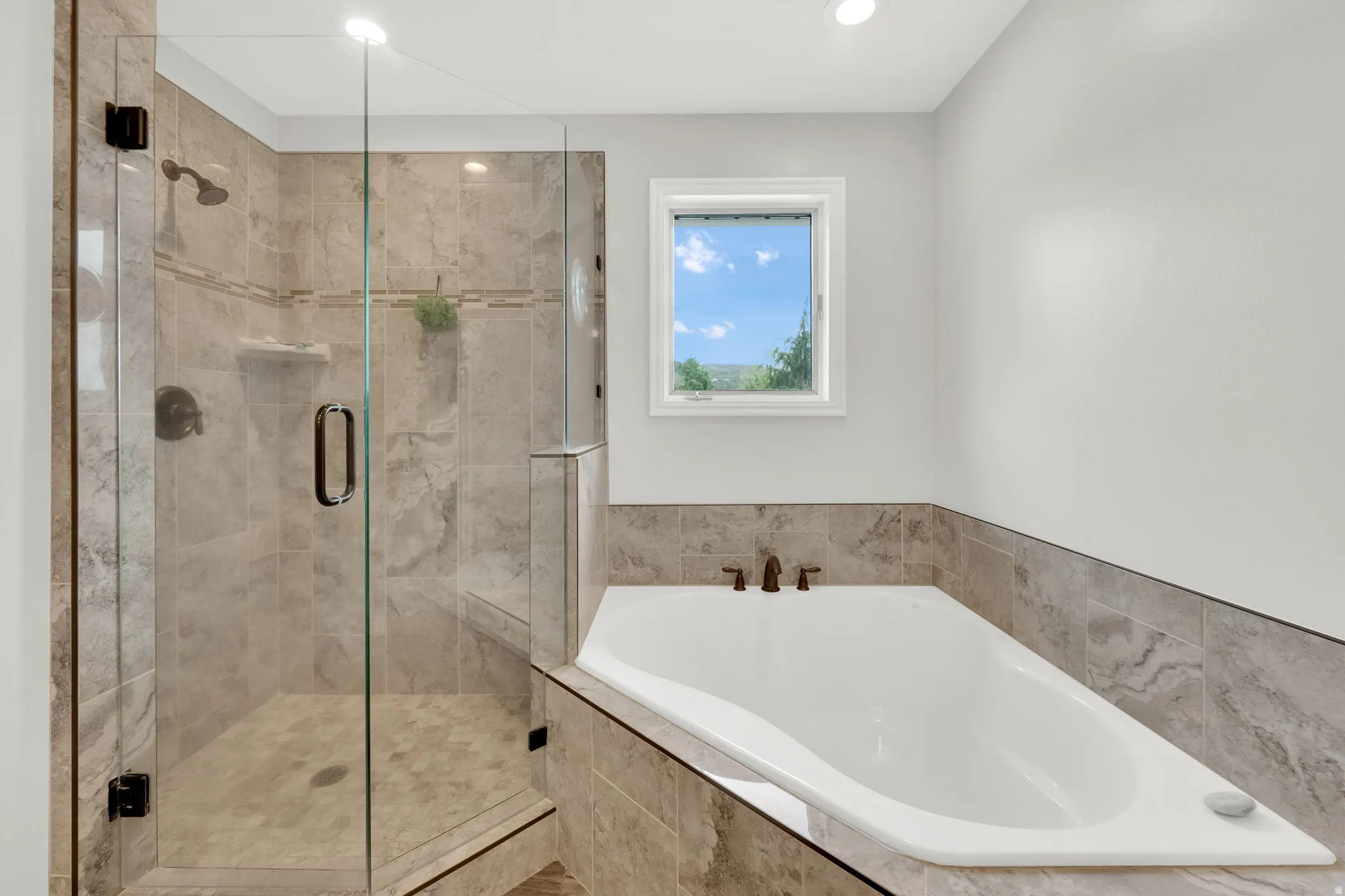 Full bathroom with a stall shower, a garden tub, and recessed lighting