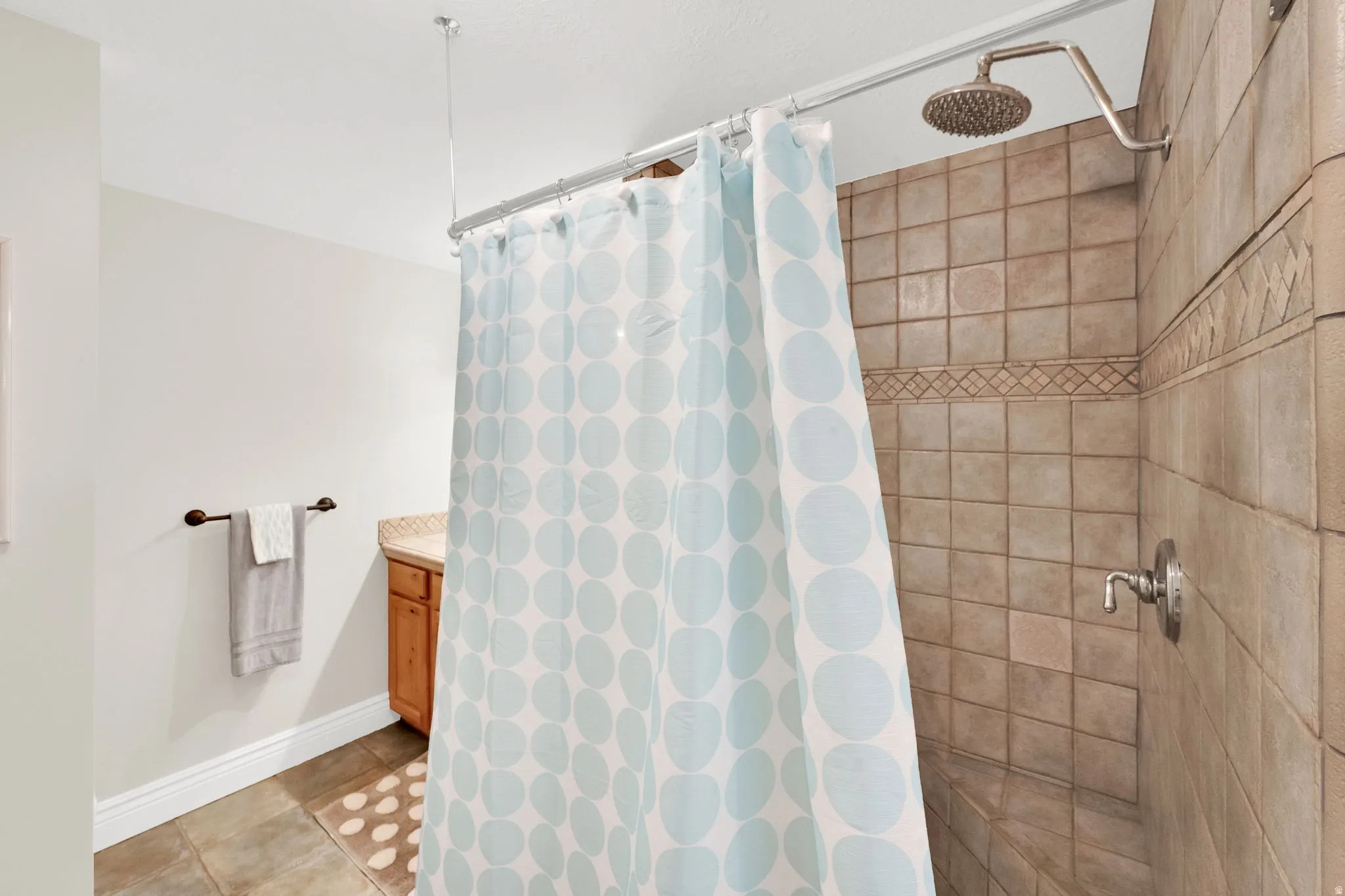 Bathroom featuring vanity, a shower stall, and light tile patterned floors