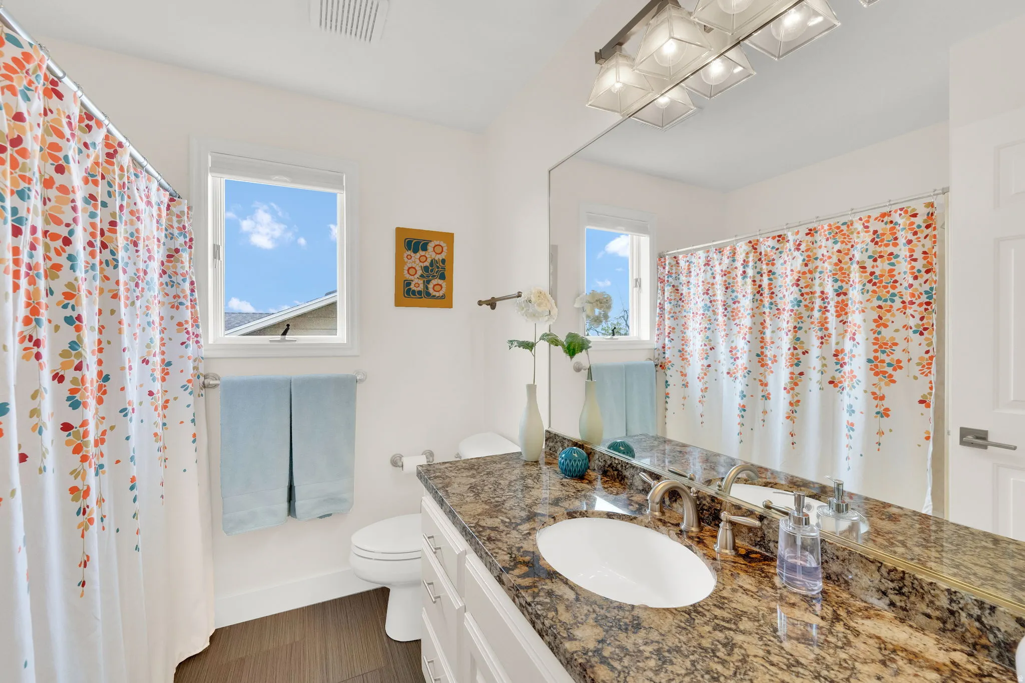 Bathroom with vanity, curtained shower, and dark floors