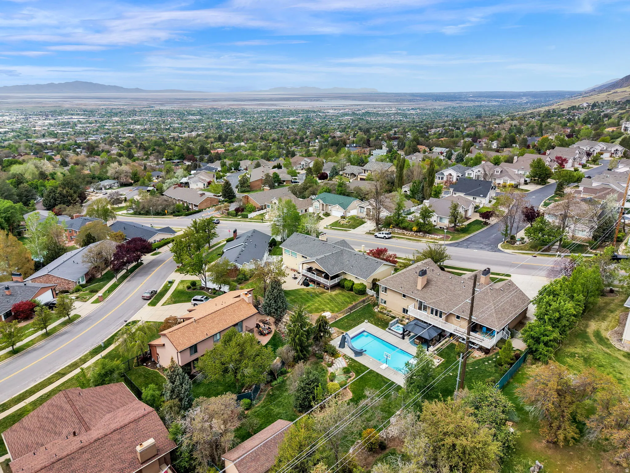 Aerial perspective of suburban area with mountains and a pool