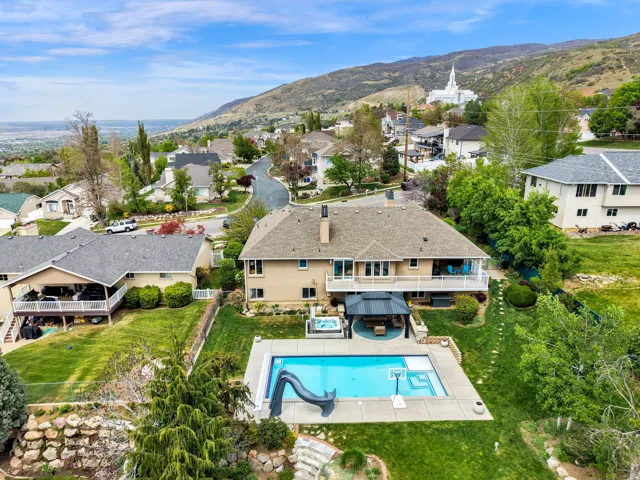 Aerial view of residential area featuring mountains, temple & pool