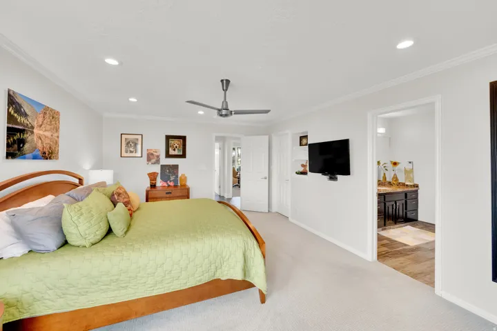 Master Bedroom featuring light colored carpet, recessed lighting, crown molding, ensuite bathroom, and ceiling fan