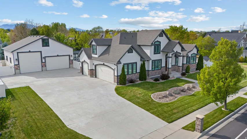 French country home featuring stone siding, stucco siding, roof with shingles, and a front lawn