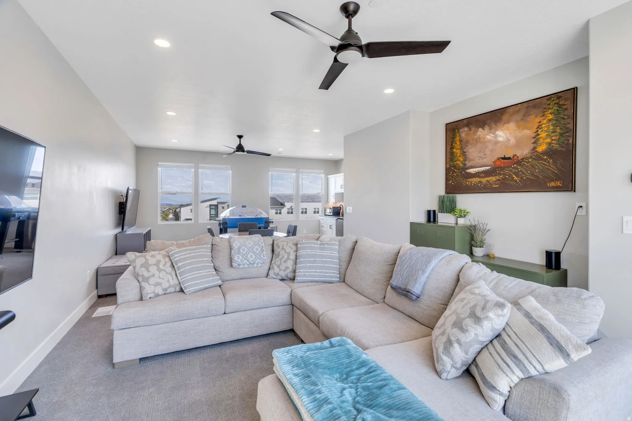 Carpeted living room with a ceiling fan and recessed lighting