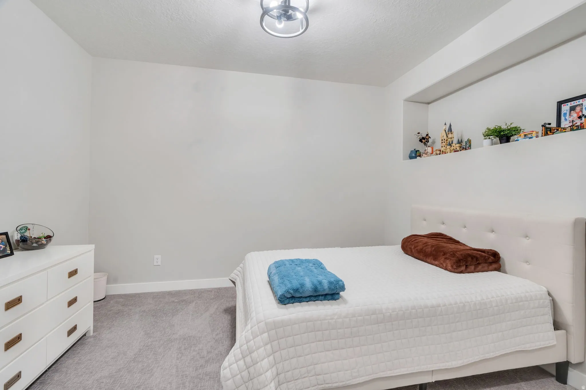 Bedroom featuring light carpet and a textured ceiling