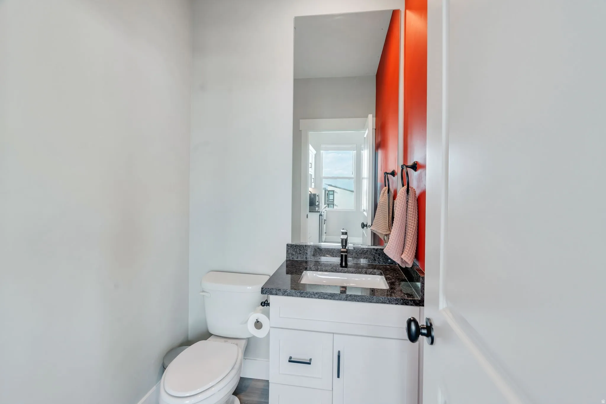 Half bathroom with vanity and toilet