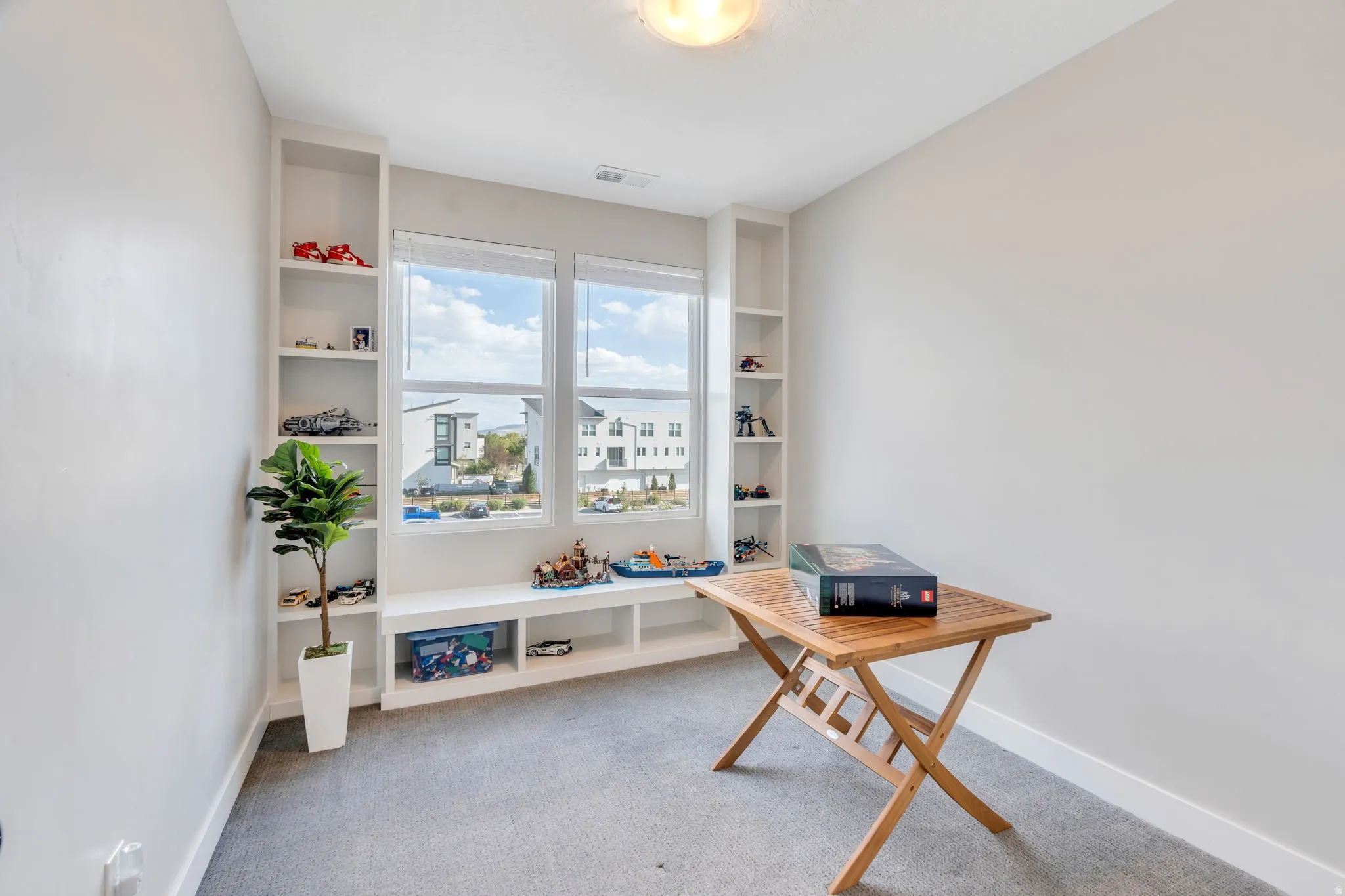 Office featuring light colored carpet and built in shelves