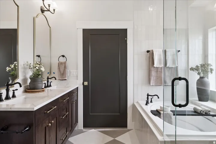 Bathroom featuring double vanity, a bath, and a shower stall