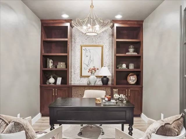 Office area with built in shelves, a chandelier, and light wood-style floors