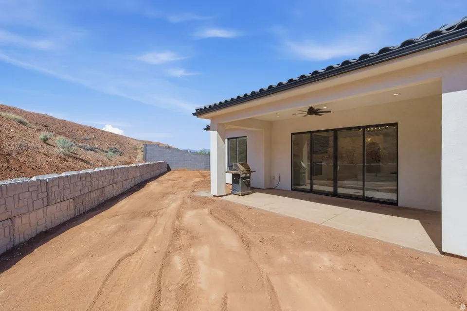 Fenced yard with a ceiling fan and a patio