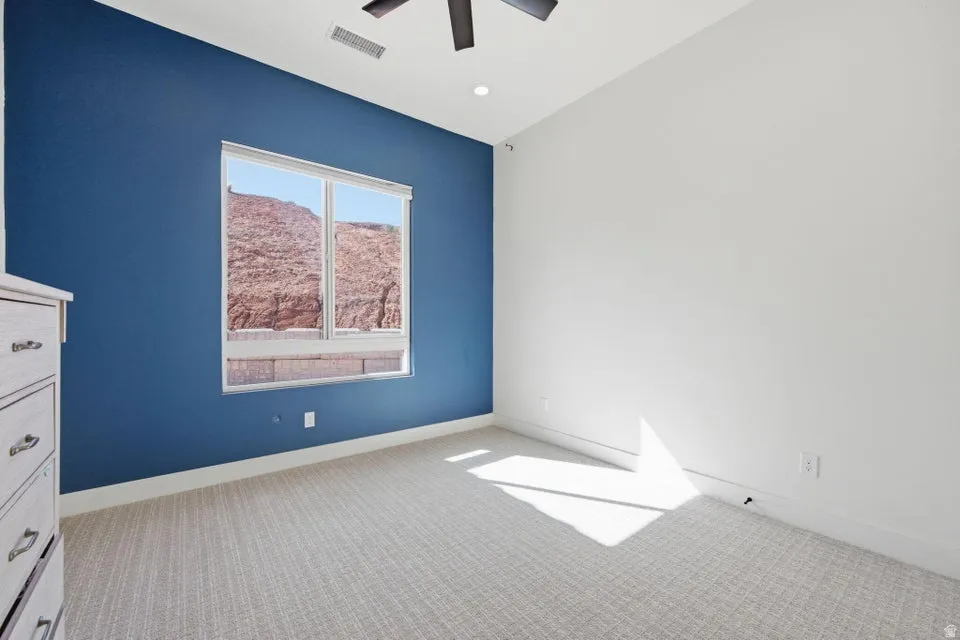 Empty room with light carpet and ceiling fan