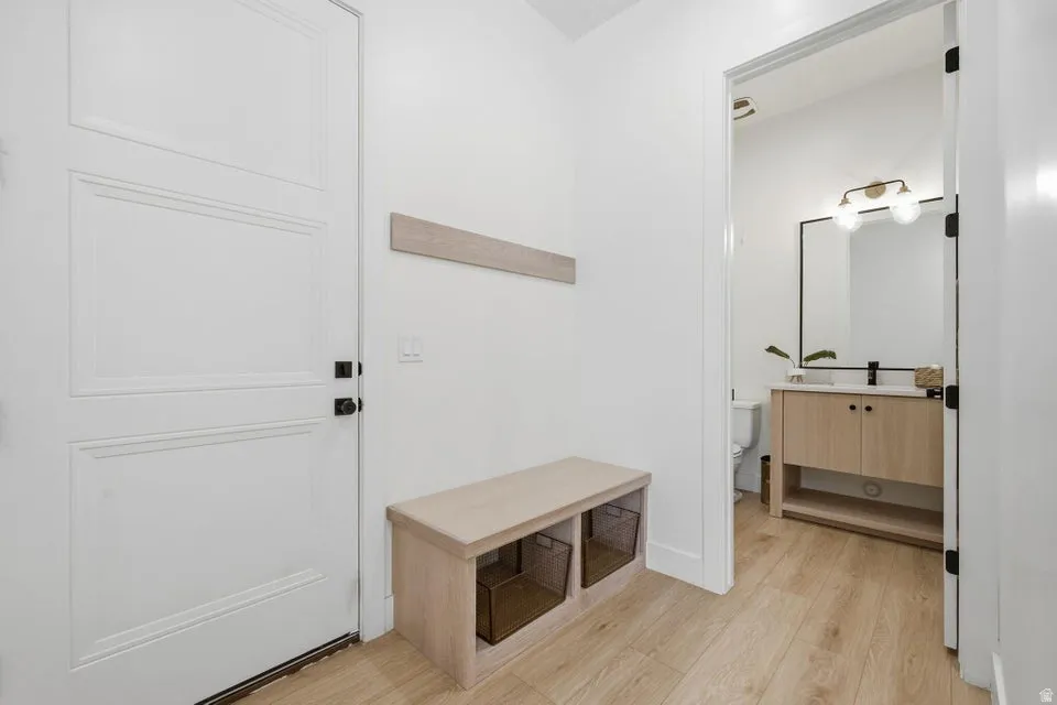 Mudroom with light wood-style floors and a sink