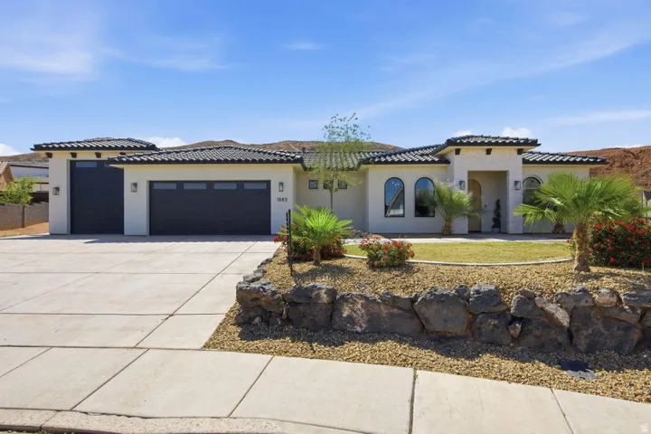 Mediterranean / spanish house featuring an attached garage, stucco siding, concrete driveway, and a tile roof