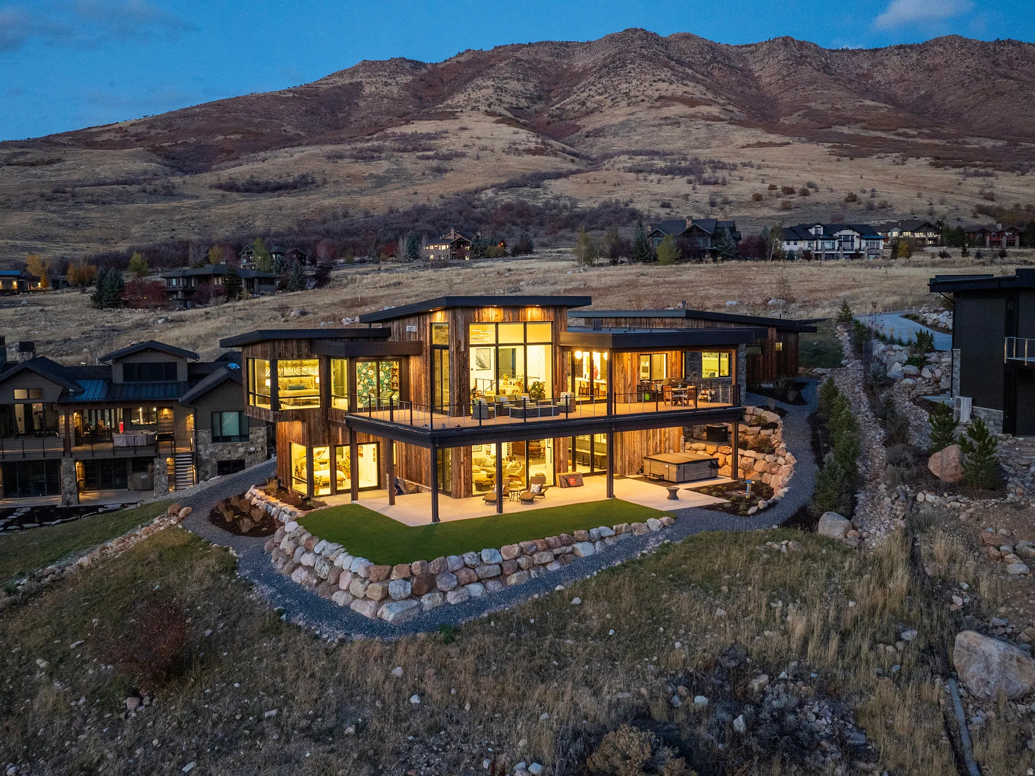 Rear view of house with a patio, a mountain view, and a lawn
