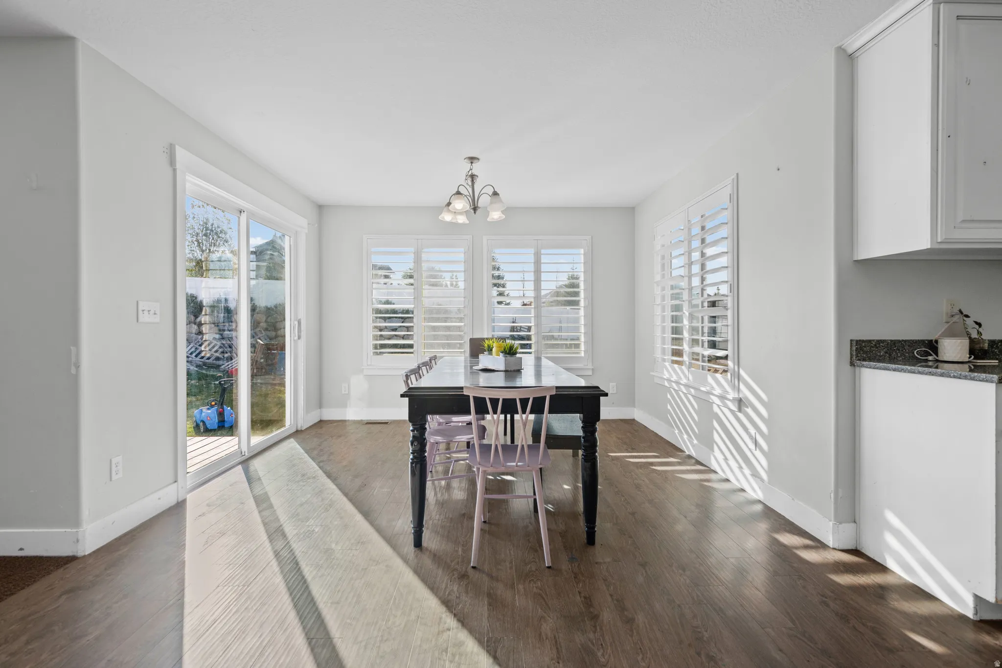 Dining room featuring dark wood-style flooring and a chandelier