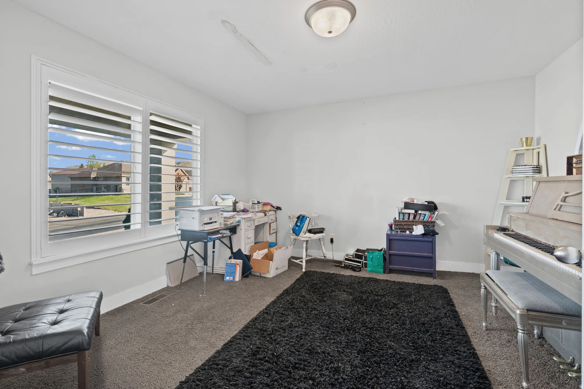 Misc room with baseboards and dark carpet