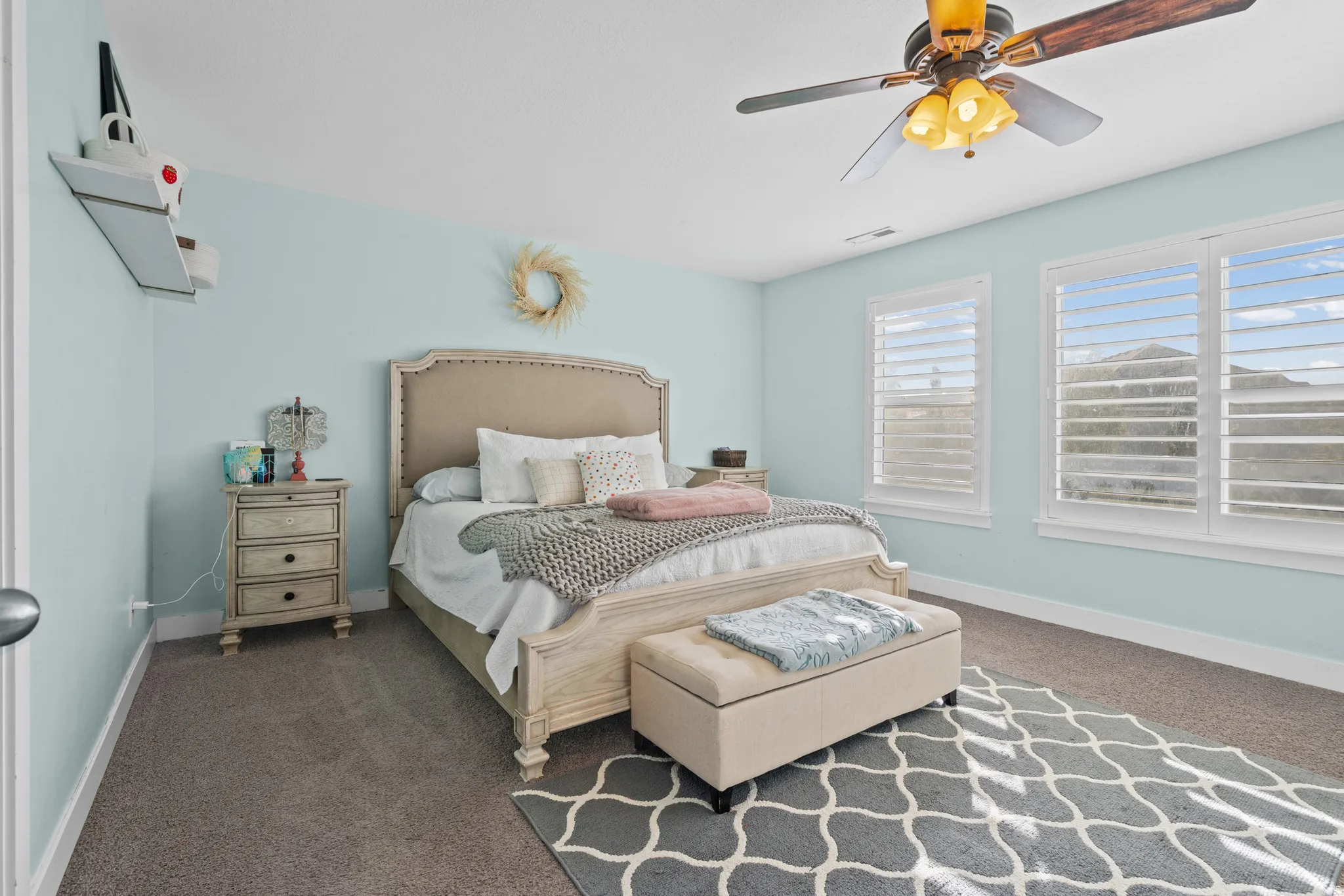 Bedroom with a ceiling fan and dark colored carpet