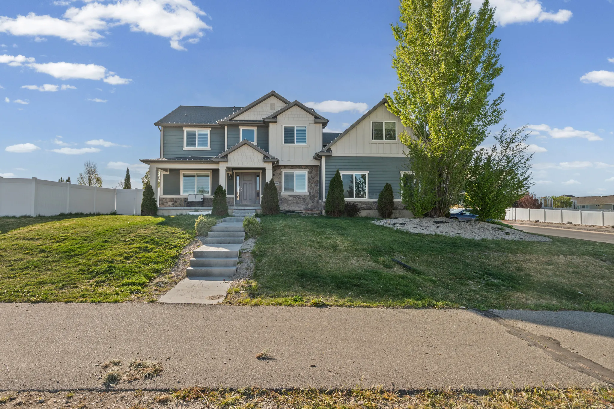 Craftsman house featuring stone siding, covered porch, and board and batten siding