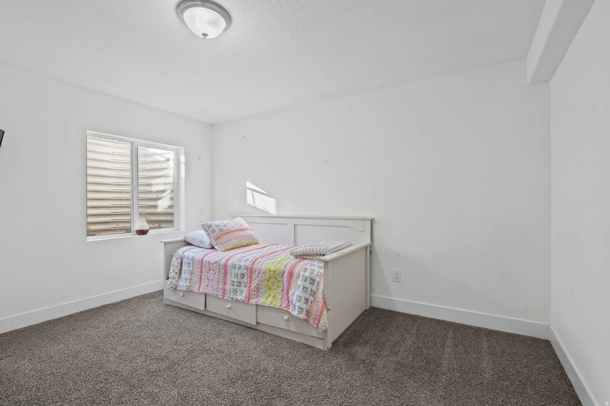 Bedroom featuring dark colored carpet and baseboards