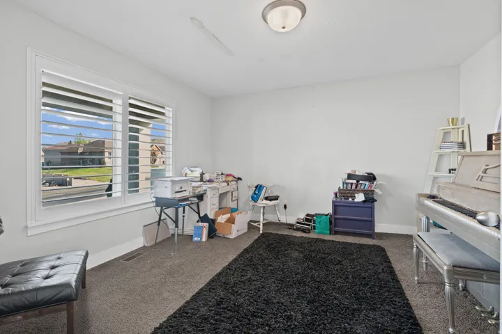 Misc room with baseboards and dark carpet