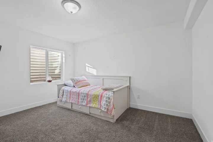 Bedroom featuring dark colored carpet and baseboards