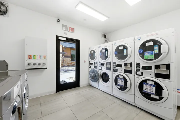 Communal laundry room featuring washing machine and clothes dryer and stacked washer / drying machine
