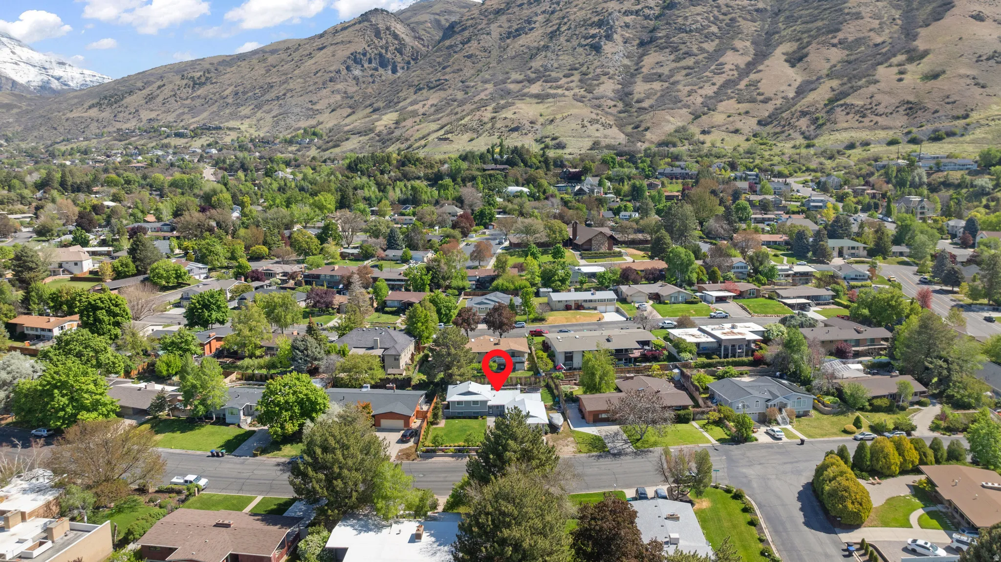 Aerial overview of property's location with a mountainous background and nearby suburban area