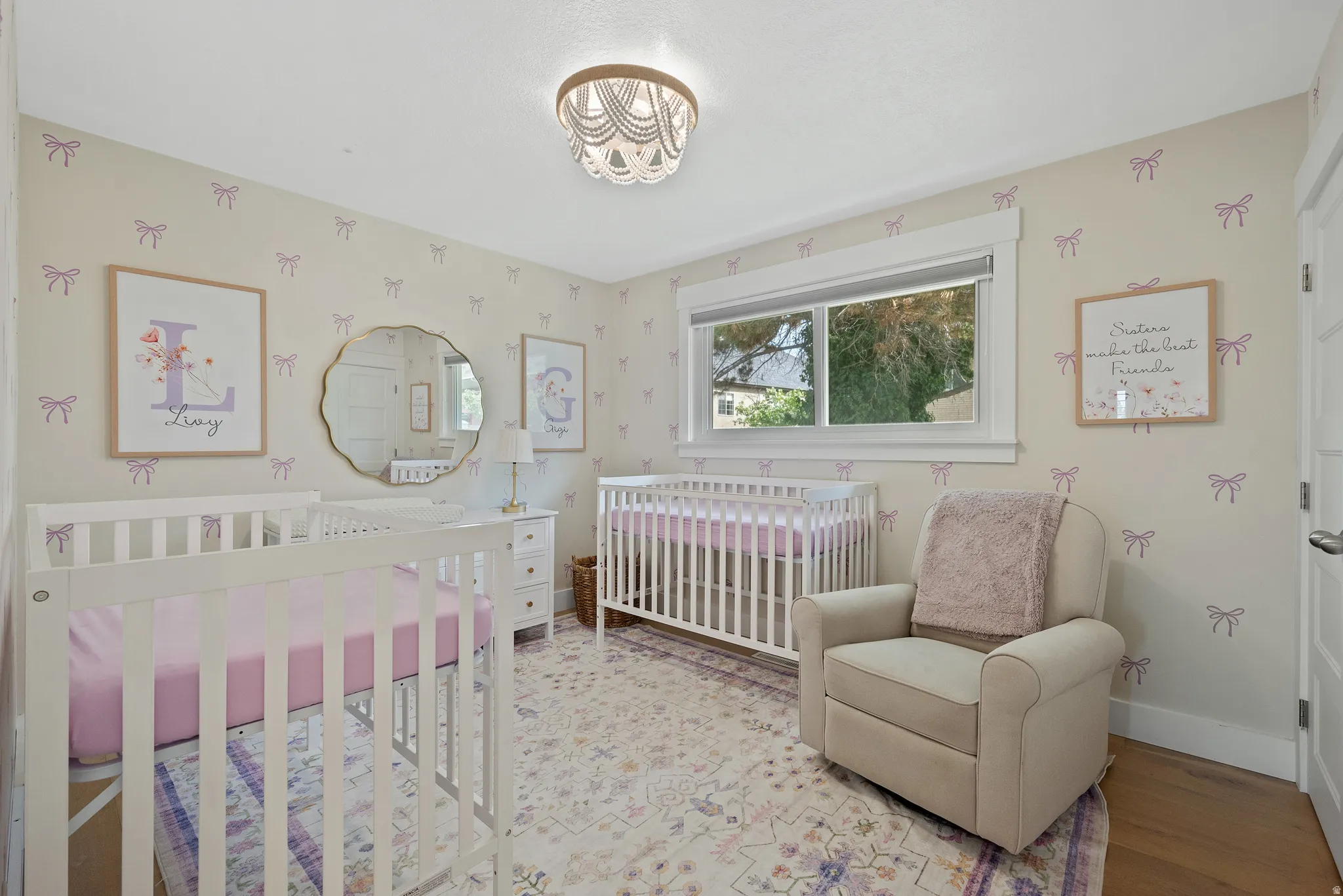 Bedroom with a nursery area and light wood-style flooring