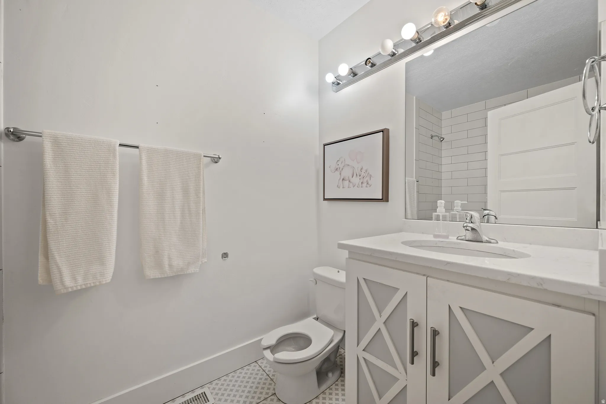 Full bathroom featuring vanity, tile patterned flooring, and a shower